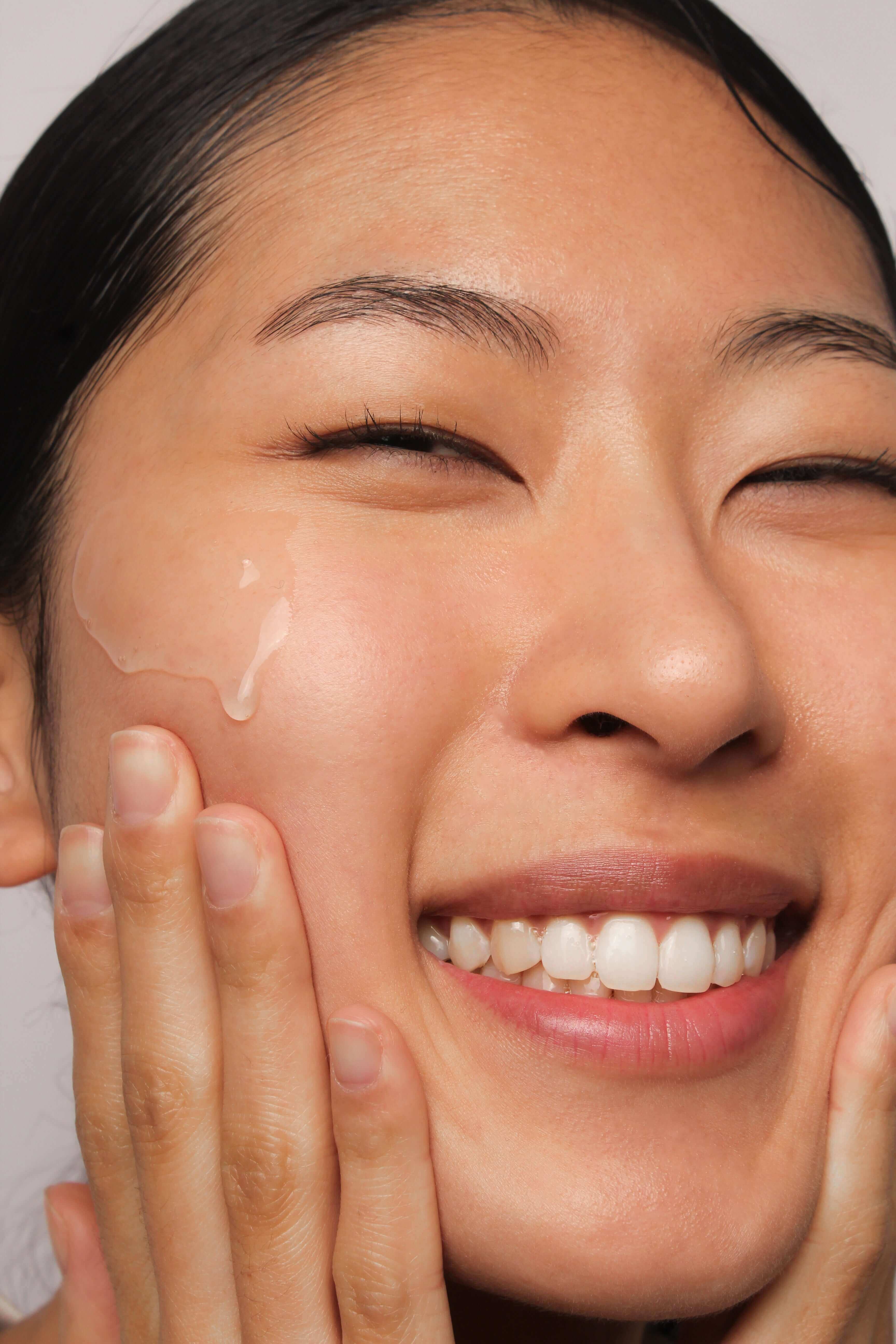 Mannequin souriante avec une goutte de produit sur le visage