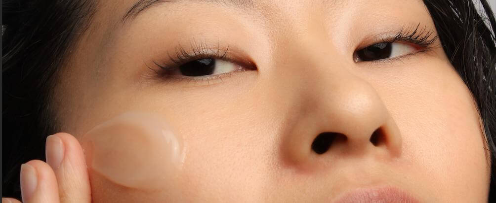 Mannequin appliquant une crème visage coréenne hydratante au riz
