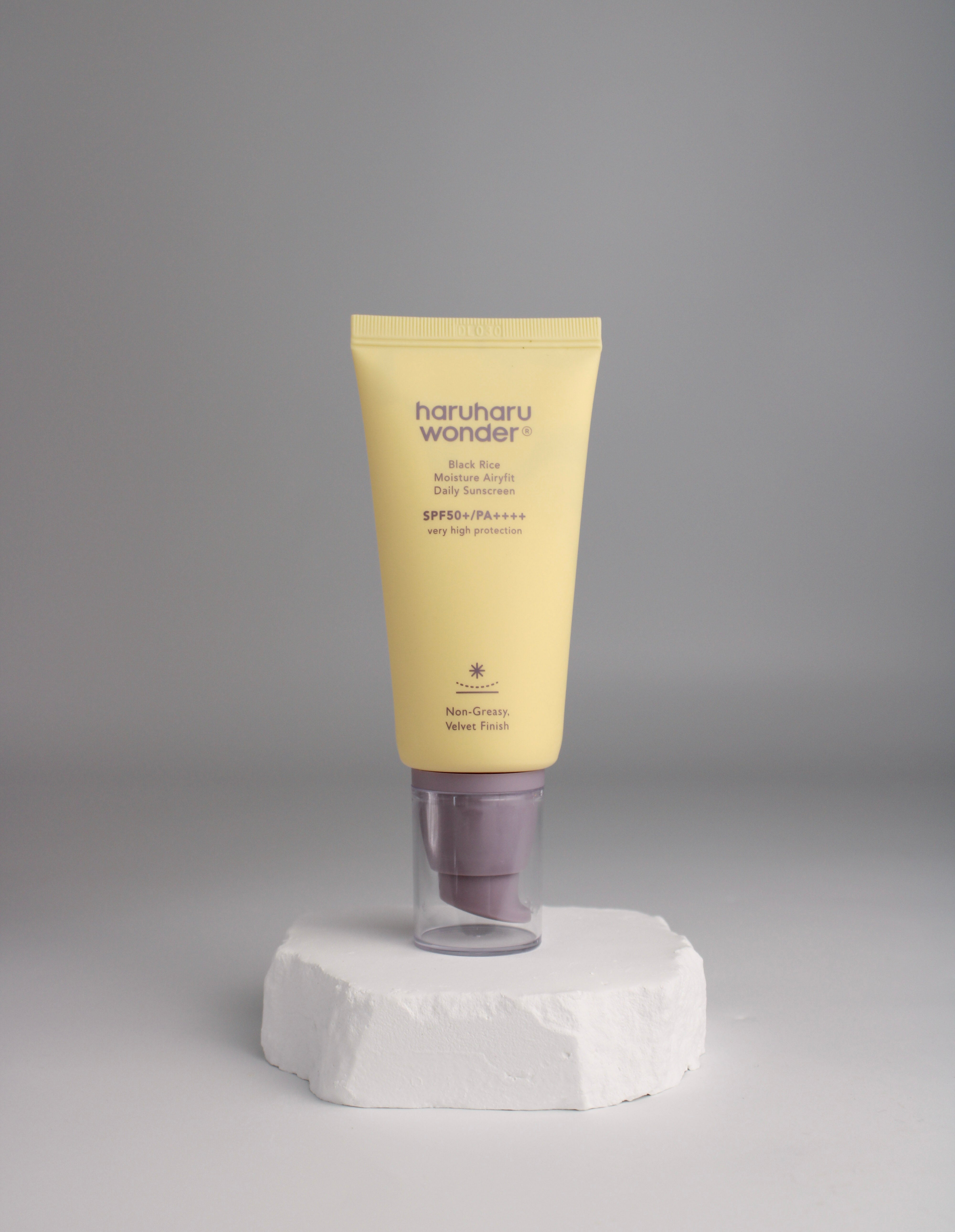 Tube de crème solaire Airyfit riz noir SPF50+ Haruharu Wonder sur fond blanc