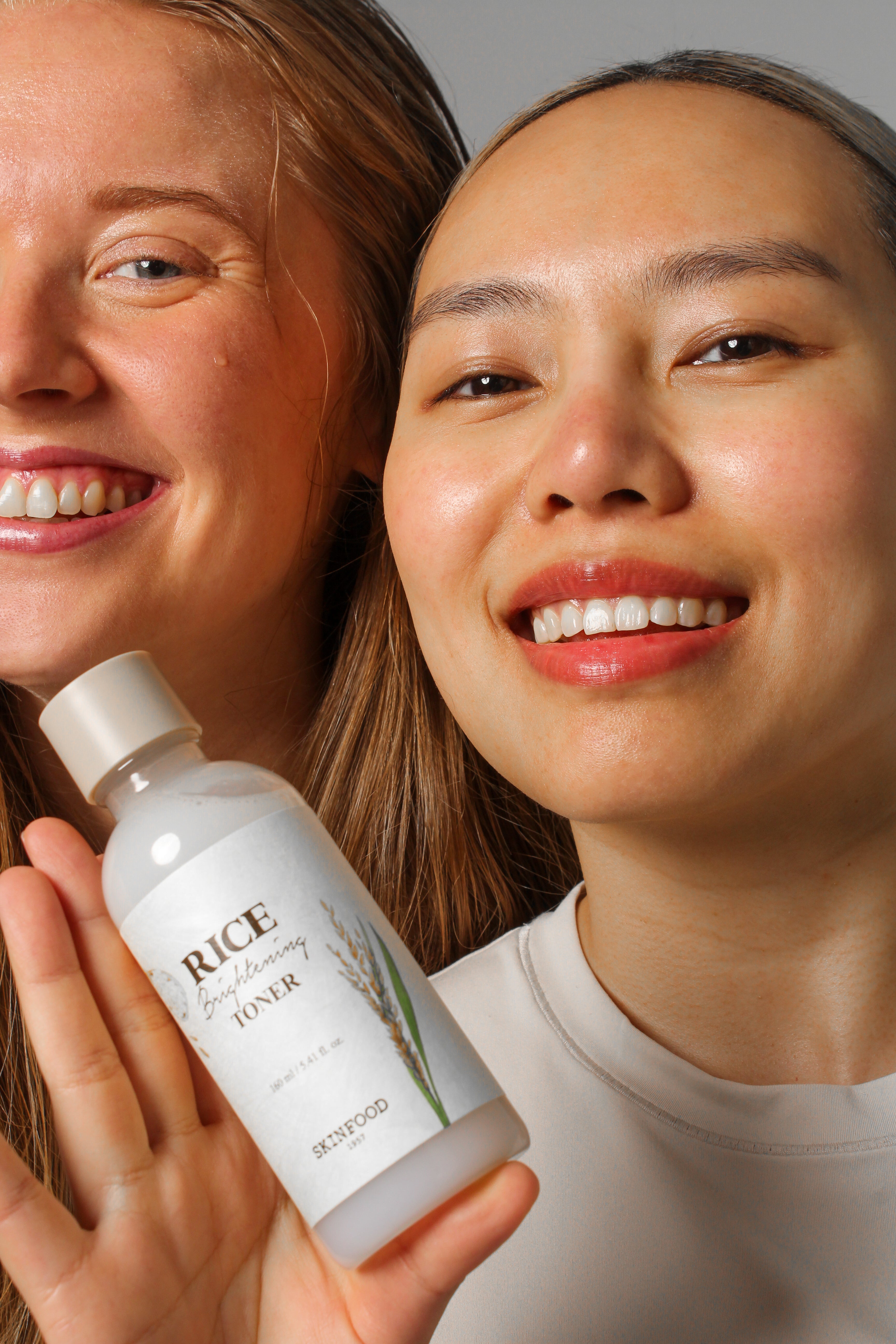 Groupe de mannequins tenant et montrant le toner éclaircissant au riz Skinfood