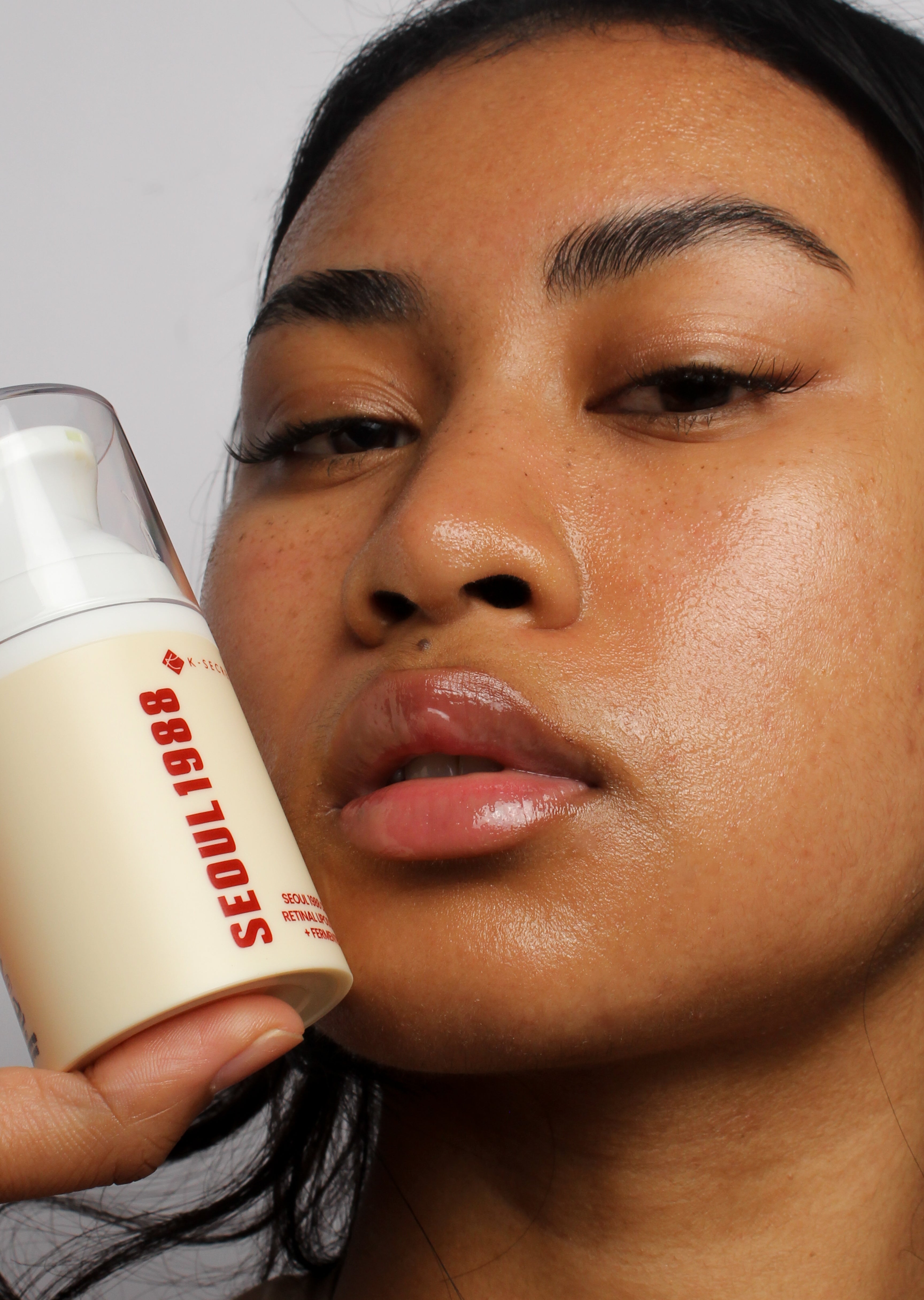 Mannequin tenant la crème rétinal encapsulé 1% + riz fermenté Seoul 1988, peau lumineuse