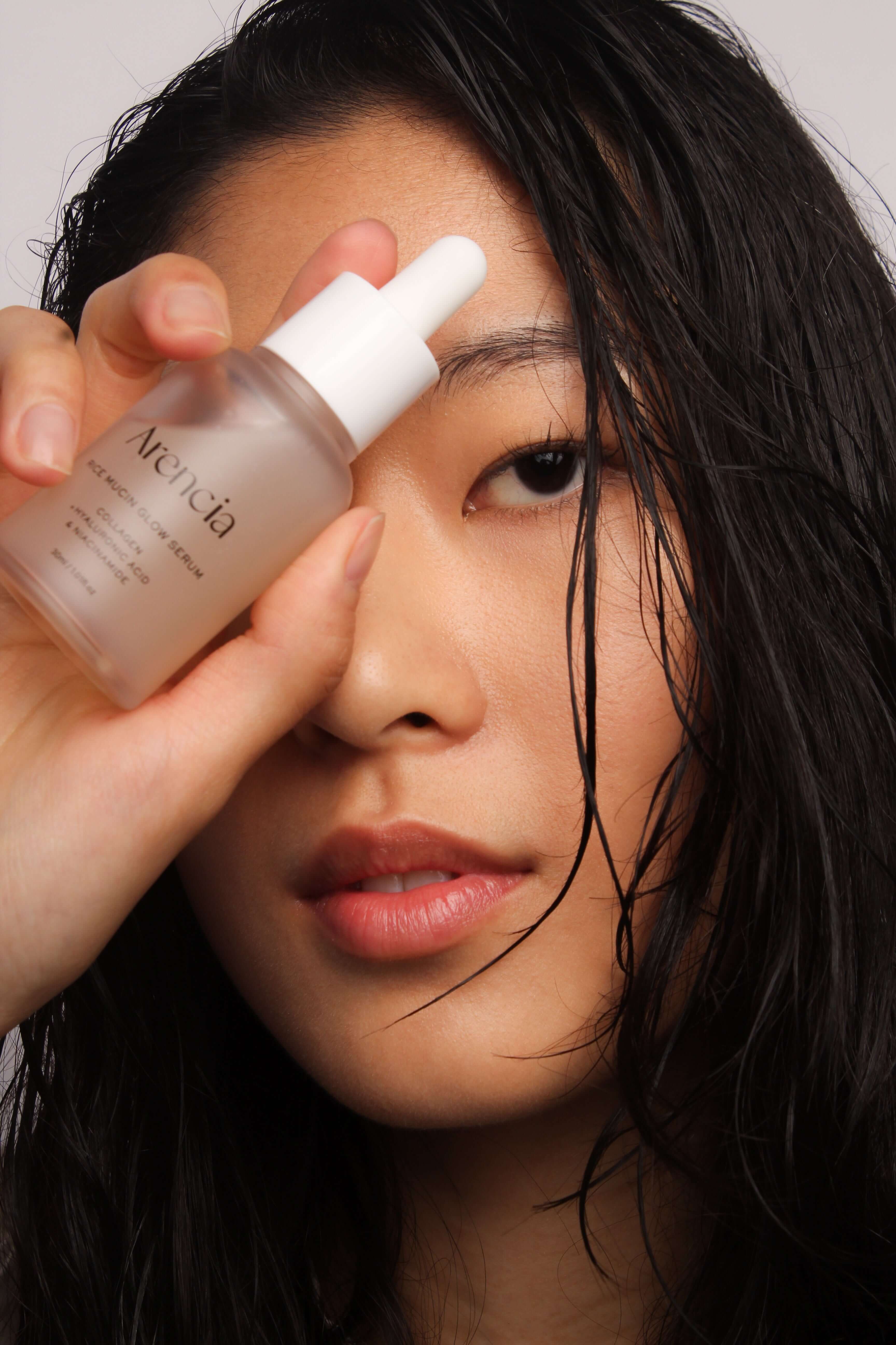 Mannequin tenant le sérum Arencia à la mucine de riz, routine éclat visage