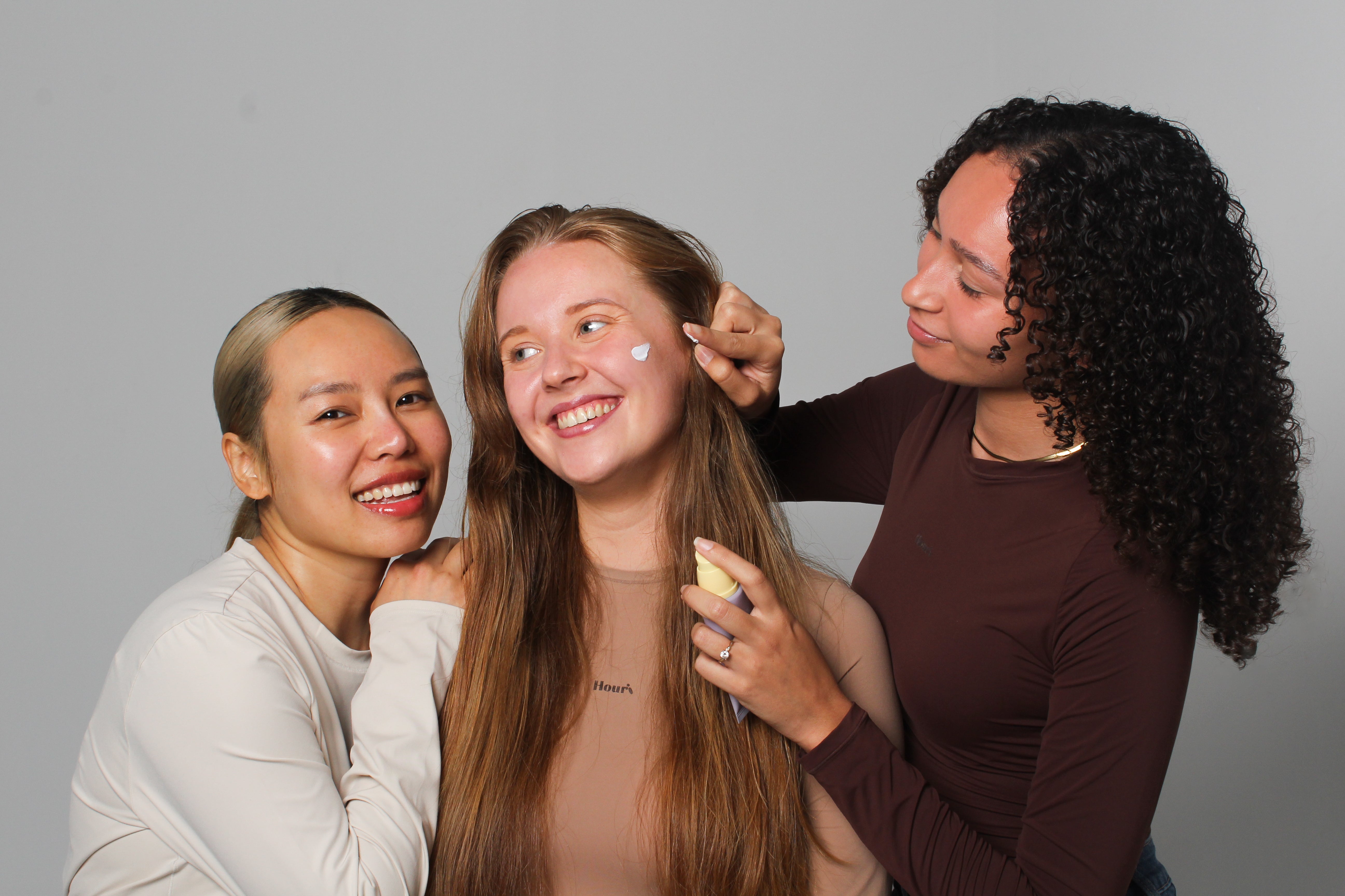 Groupe de mannequins appliquant la crème solaire pure mineral relief riz noir Haruharu Wonder sur la peau