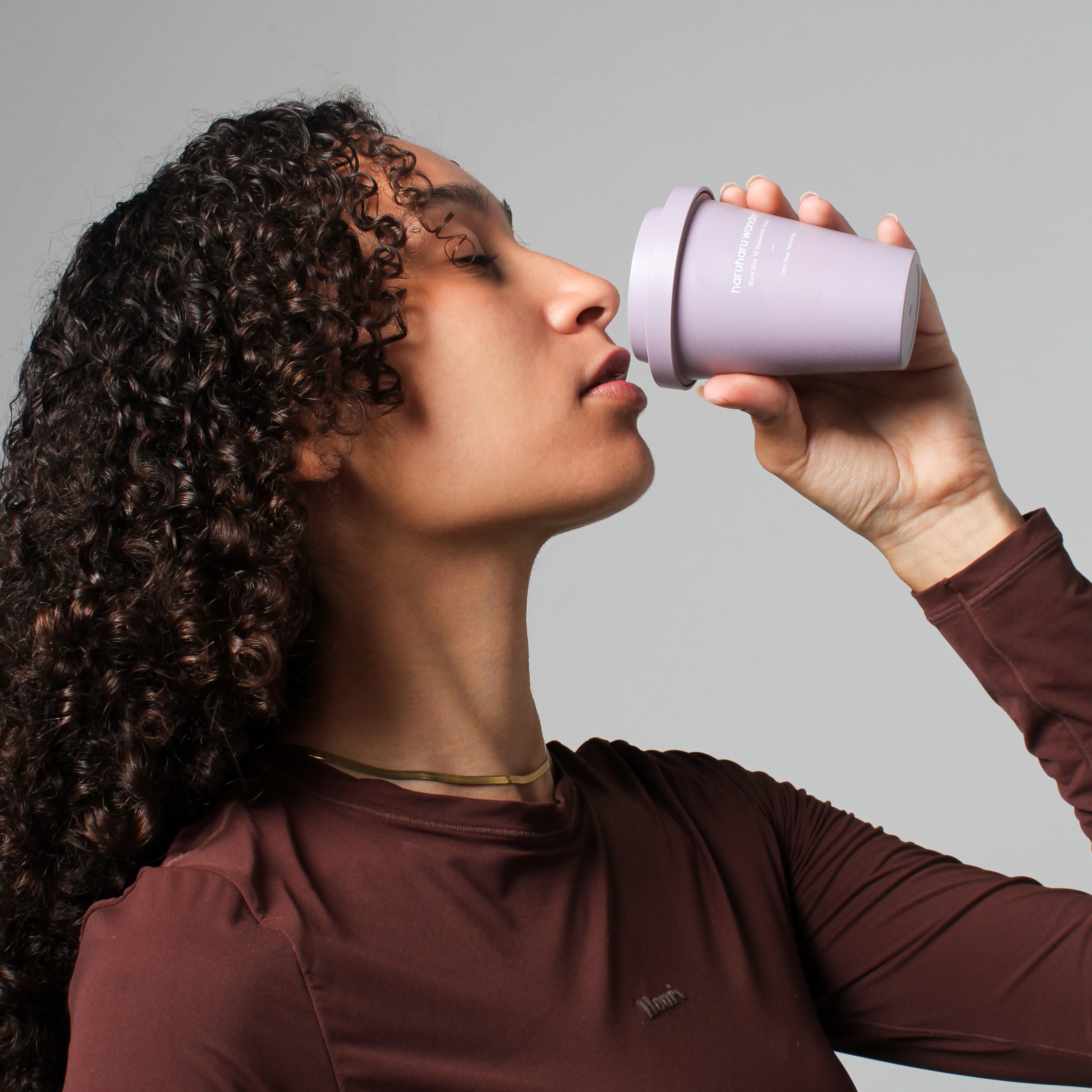 Mannequin dégustant la Crème 10 Hyaluronique Riz Noir - 90ml Haruharu Wonder présentée sous forme de gobelet original