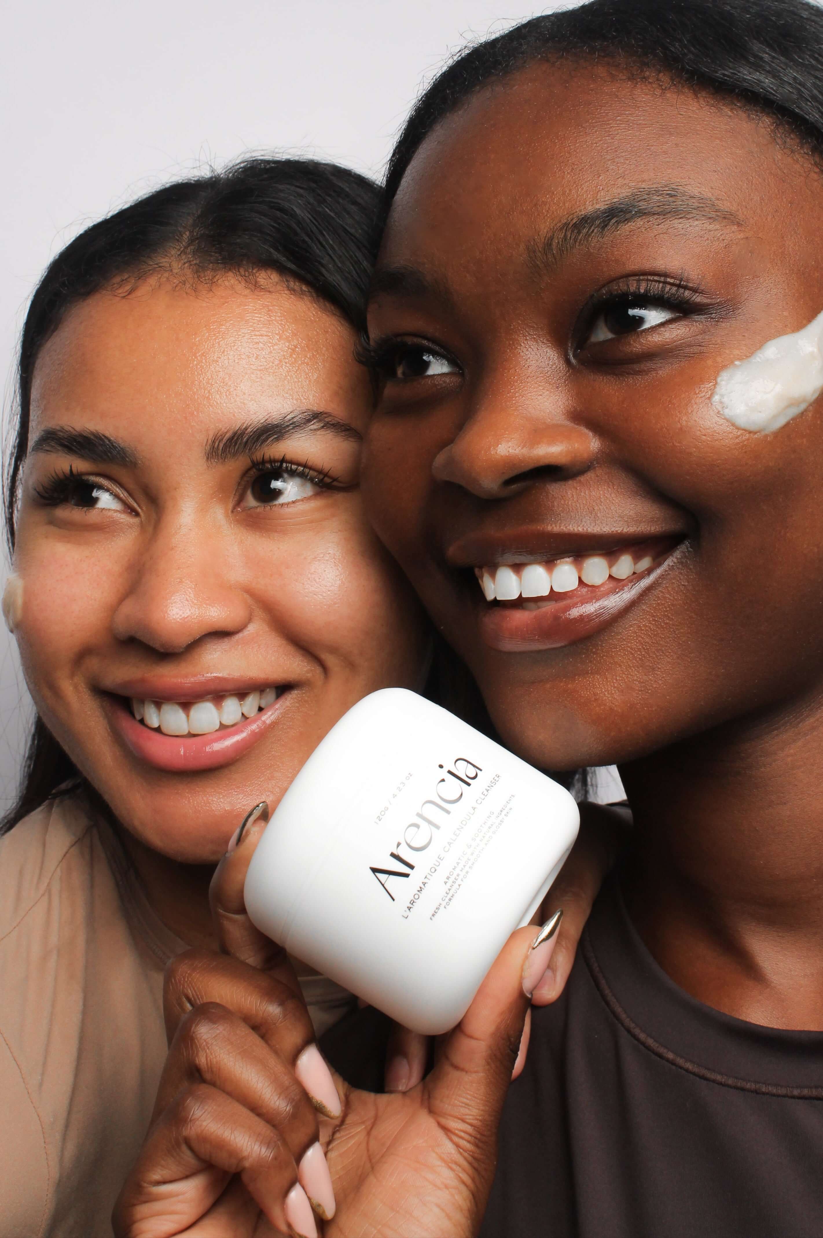 Deux mannequins tenant le nettoyant Arencia au calendula et mochi, adapté à tous types de peau