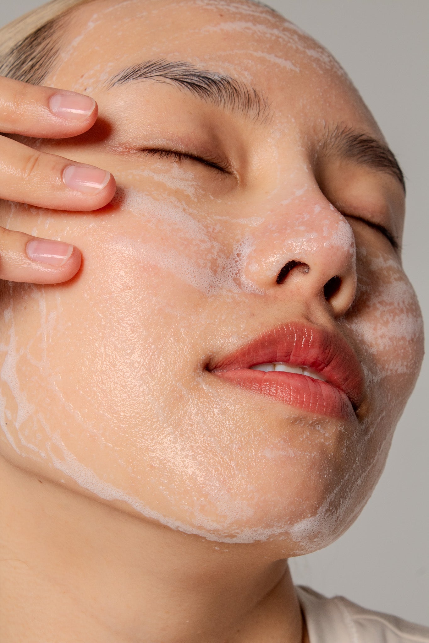 Mannequin appliquant la barre nettoyante au riz à faible pH Beauty of Joseon sur le visag