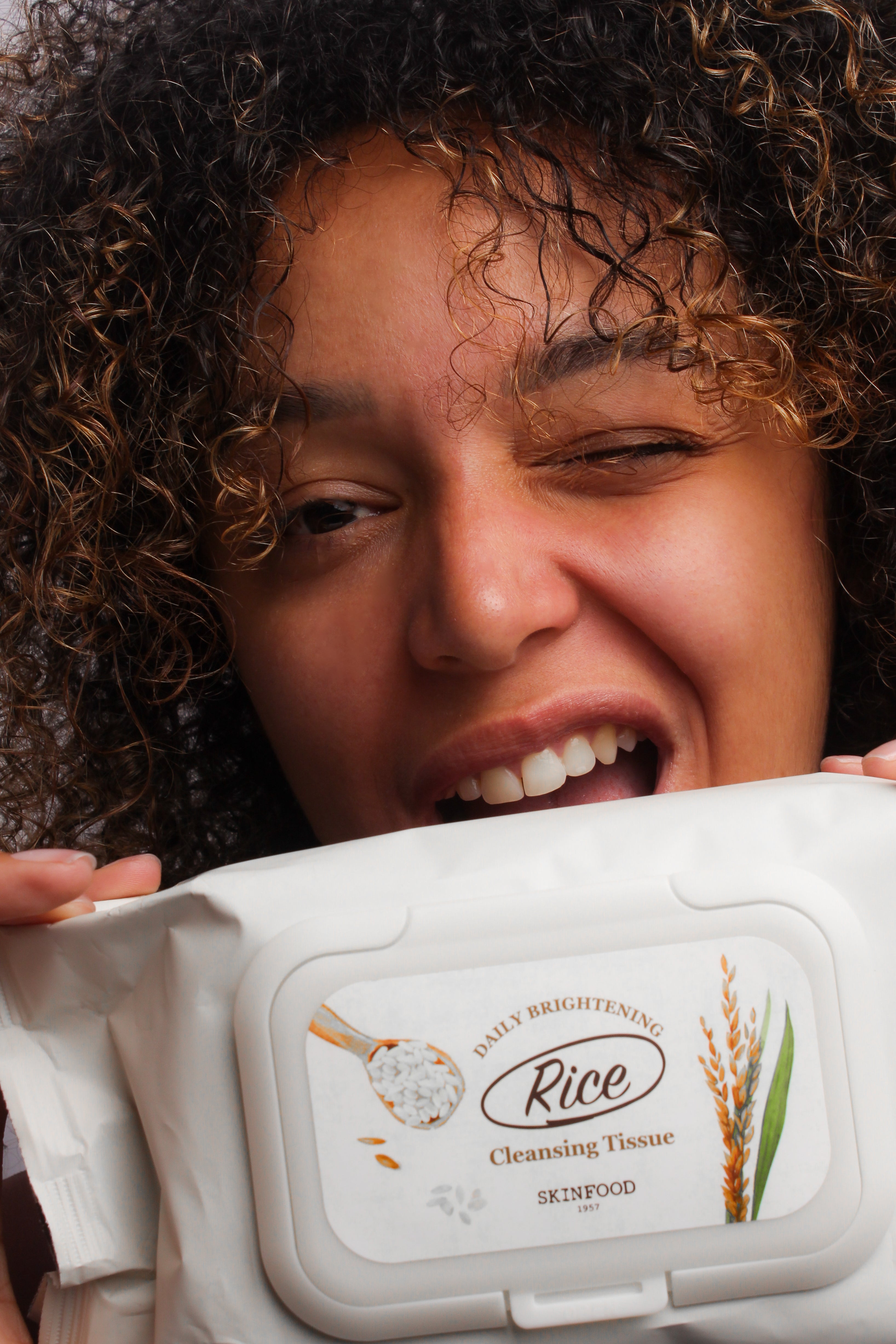 Mannequin jouant avec le paquet de lingettes nettoyantes éclaircissantes au riz Skinfood, moment ludique