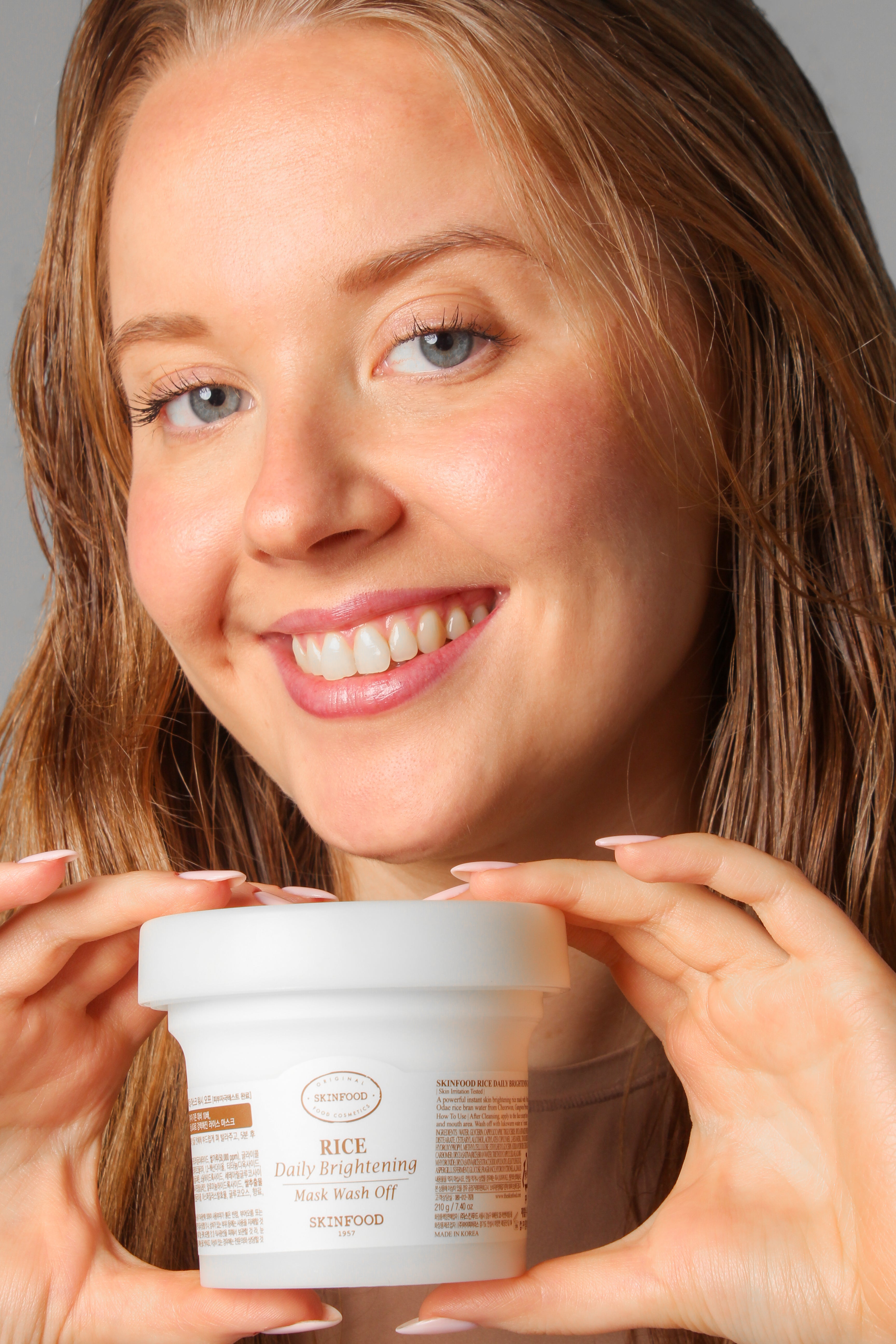 Mannequin tenant le pot du masque nettoyant éclaircissant au riz Skinfood