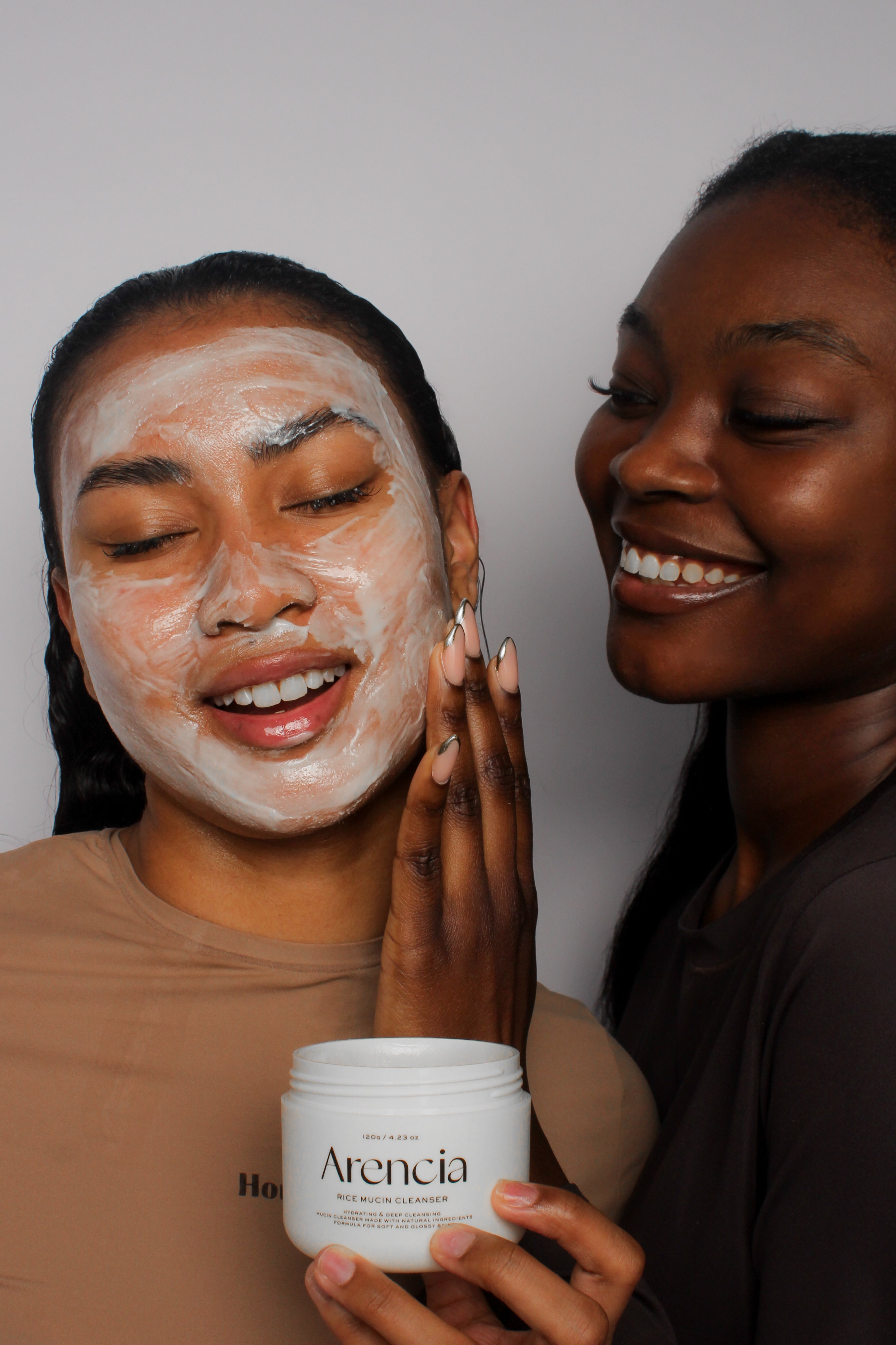 Application du nettoyant à la mucine de riz Arencia entre deux mannequins, rituel skincare doux et complice